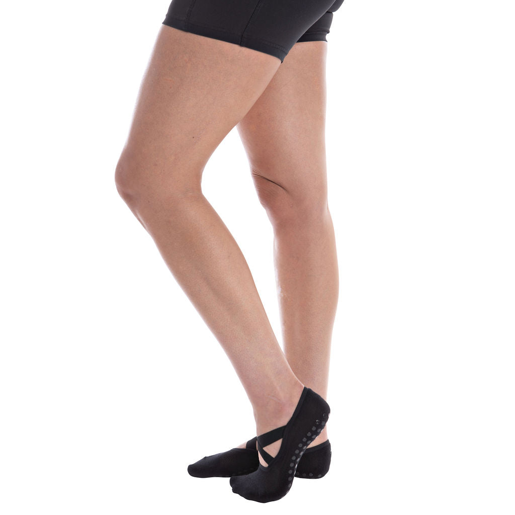 Person wearing black ballet grip sock on a white background
