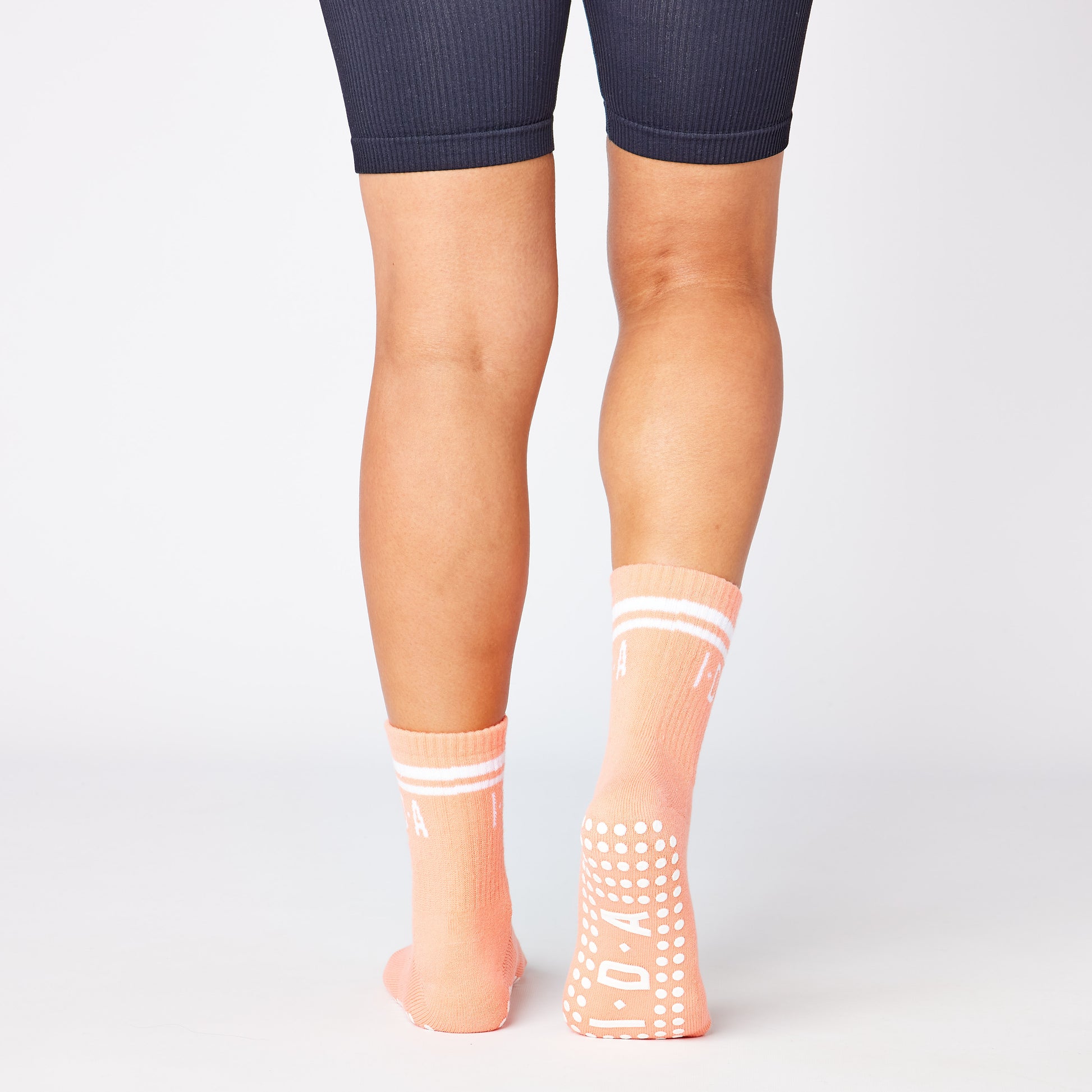 Pair of peach-colored socks with white grip sole 