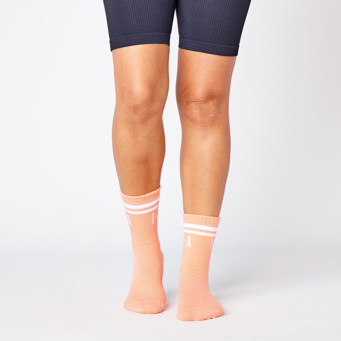 Pair of peach-colored socks with white grip sole 