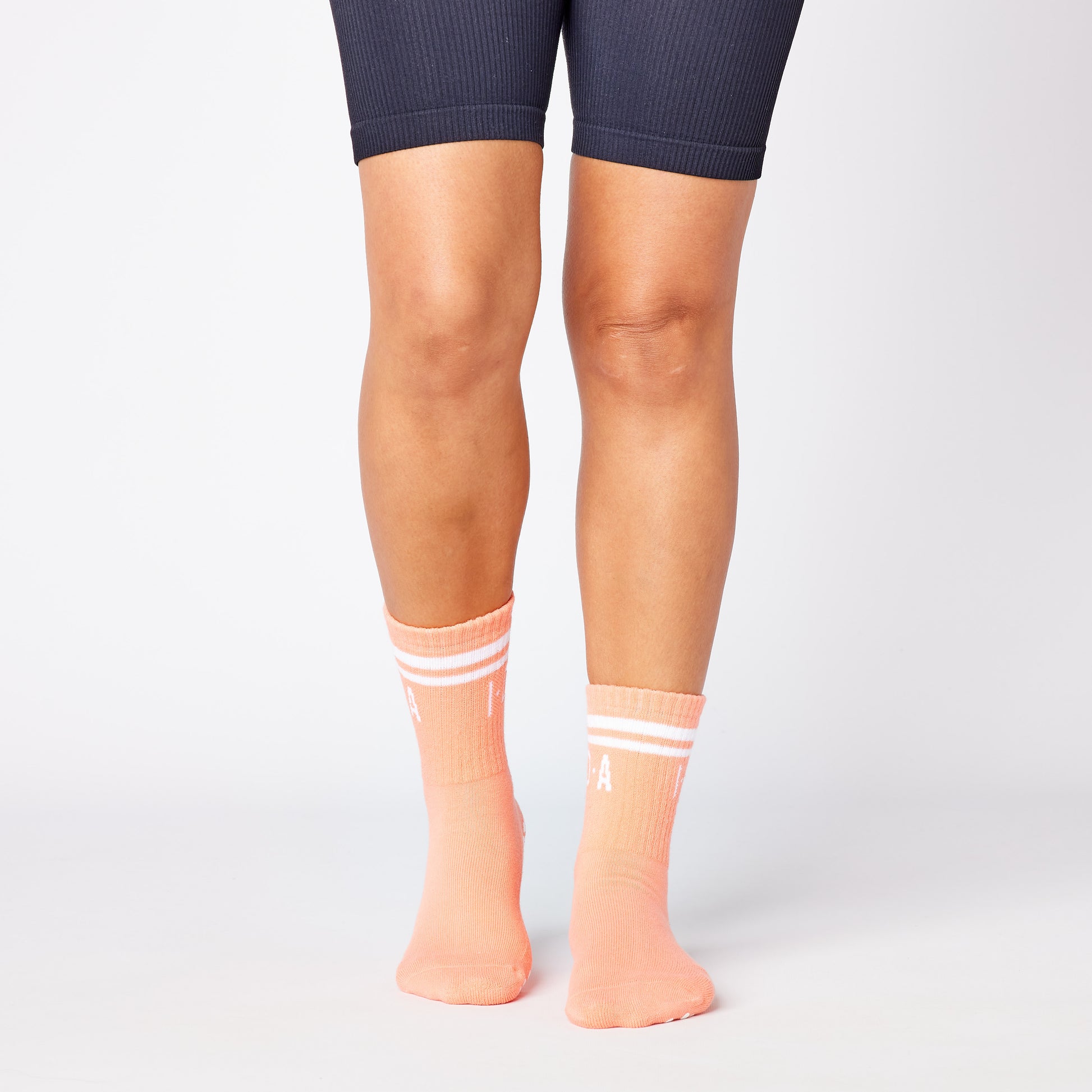 Pair of peach-colored socks with white grip sole 