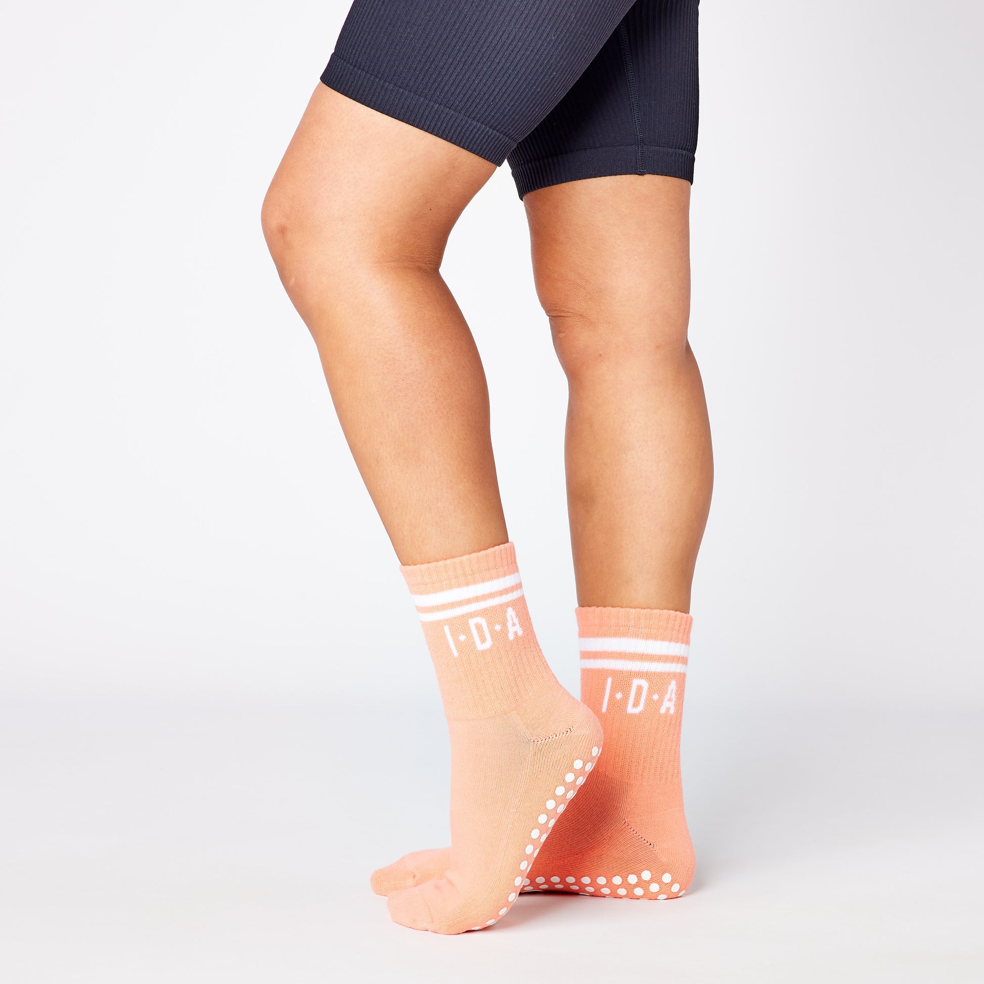 Pair of peach-colored socks with white grip sole 